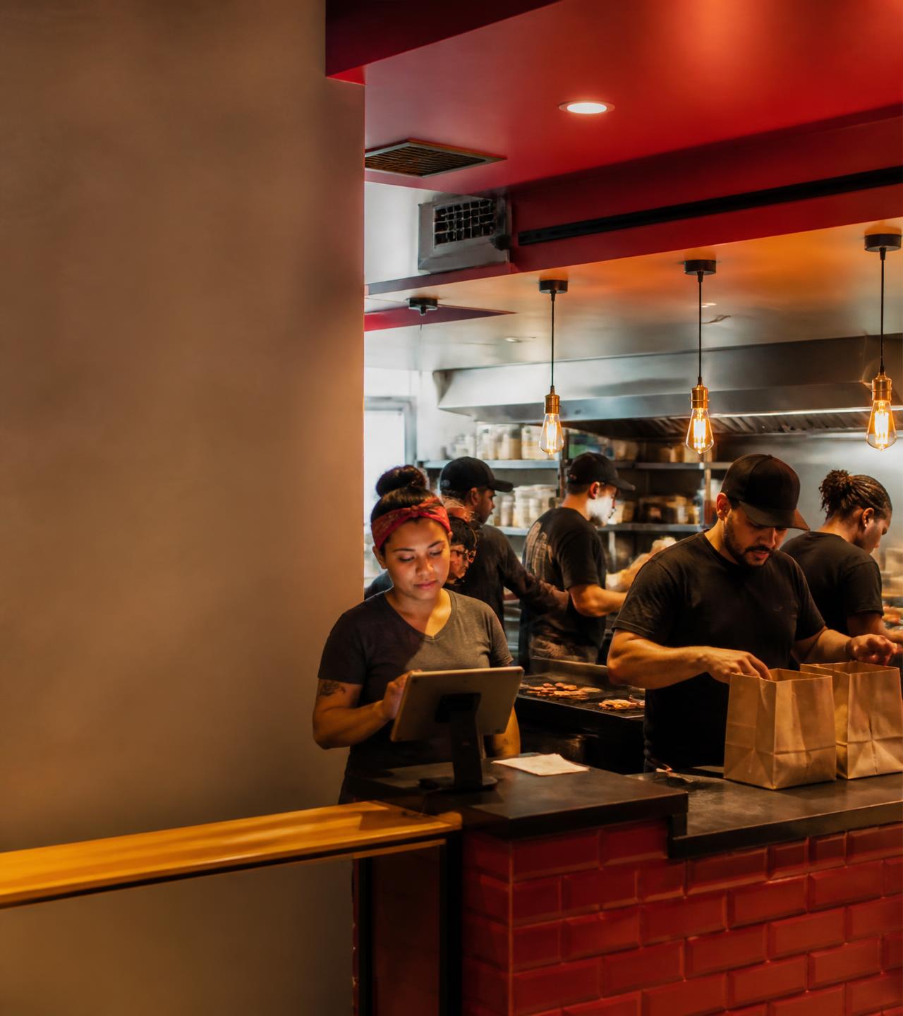 Equipe de uma hamburgueria brasileira trabalhando com o SofChef no balcão